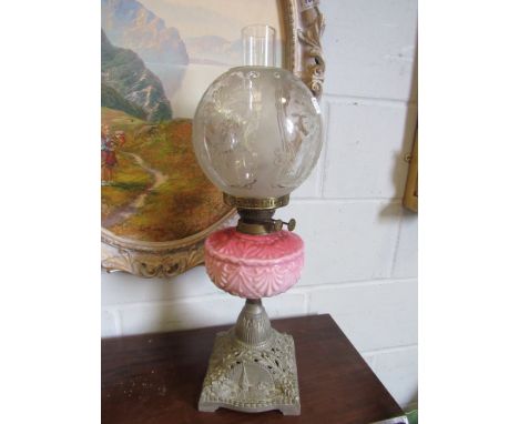 A Victorian oil lamp with acid etched shade, pink reservoir and pierced cast metal base, 58cm tall