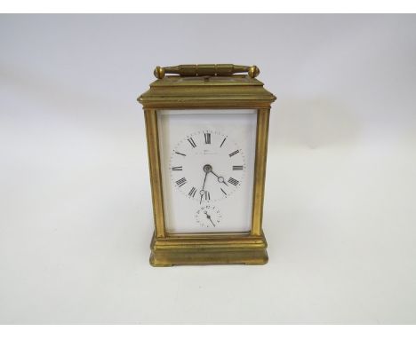 An early 20th Century French brass carriage clock with strike repeater and alarm, Roman enamel dial with moon hands, retailer