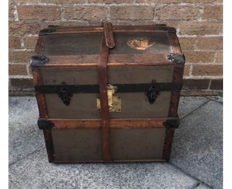 AN OAK AND LEATHER TRAVELLING TRUNK  with leather carrying handles to each side the hinged top opening to reveal a lift out c