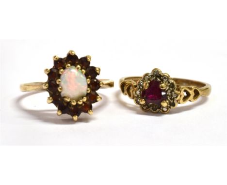 A 9CT GOLD RUBY SET RING With the central ruby shaped as a heart and the ring shoulders of open work heart shape, marked 375 