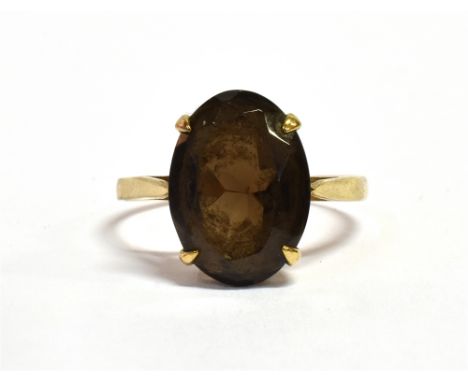 A 9CT GOLD QUARTZ COCKTAIL RING The large oval faceted purple tinted smoky quartz stone measuring quartz approx. 1.4cm by 1 c