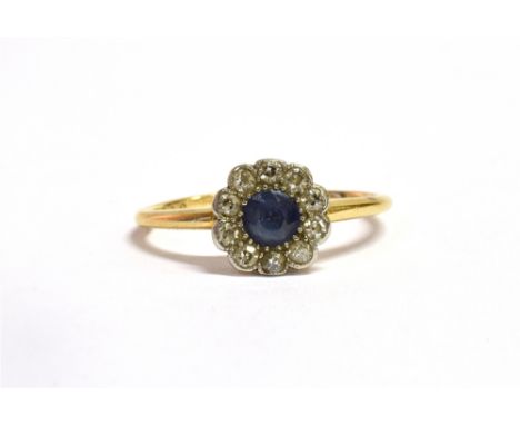 AN ART DECO DIAMOND AND SAPPHIRE DAISY HEAD GOLD RING With the central faceted round cut sapphire of a 'cornflower blue' shad