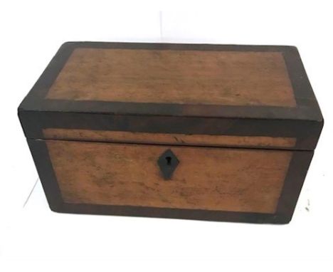 A 19TH CENTURY WALNUT TEA CADDY having an  escutcheon to the centre, the hinged top opening to reveal a central lidded compar