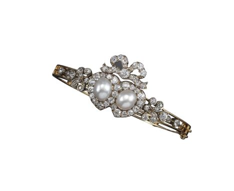 A natural pearl and diamond bangle, the two button-shaped pearls set within a surround of diamonds to form two clusters of in