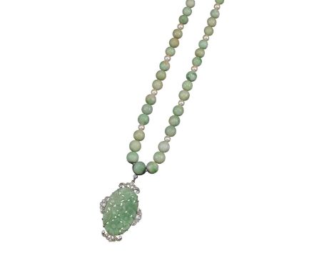 A floral carved and pierced oval jade pendant, quartered with scroll-shaped sections of baguette and circular-cut diamond-set