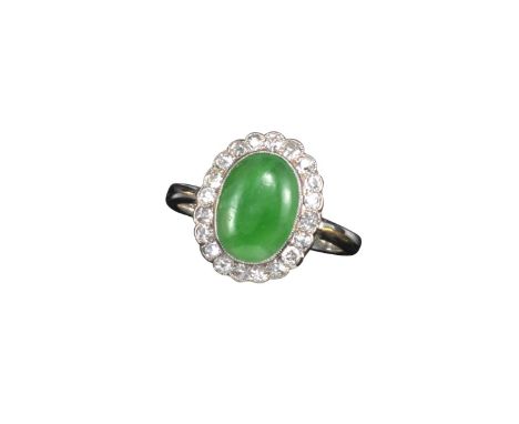 A jade and diamond cluster ring, the oval-shaped jade cabochon set within a surround of circular-cut diamonds in white gold, 