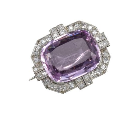 An Art Deco pink topaz and diamond brooch, the large cushion-shaped pink topaz weighs approximately 16.00cts and is set withi