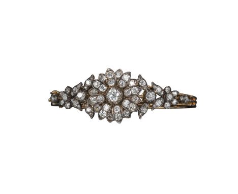 A late Victorian foliate design diamond bangle, the central flower head section detaches to be worn as a brooch, the two shou