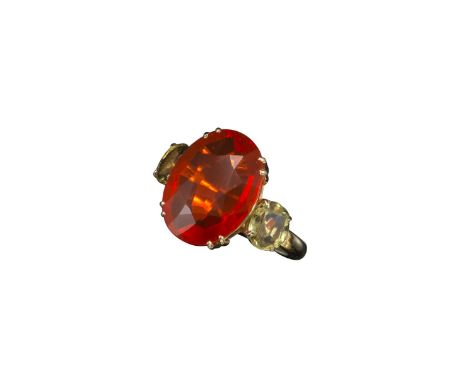 A fire opal and peridot ring, the oval-shaped fire opal set within two oval-shaped peridots in yellow gold, size L ½