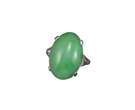 A jade and diamond ring, the oval-shaped jade cabochon set with an old circular-cut diamond to each shoulder in white gold, s