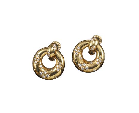 A pair of diamond and gold ear clips by Cartier, of polished door-knocker design accented by rubover-set circular-cut diamond