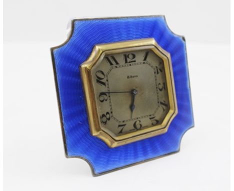 AN ART DECO DESIGN TRAVEL CLOCK, with blue guilloche enamel frame, 8 days movement, silvered dial with Arabic numerals, havin