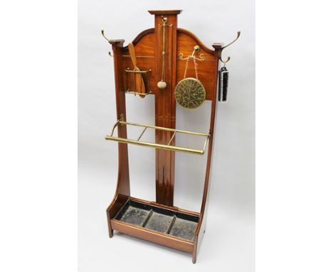 AN EDWARDIAN MAHOGANY HALL STAND, fitted brass gong with hammer, brass clothes brush holder, brass coat hooks and brass stick