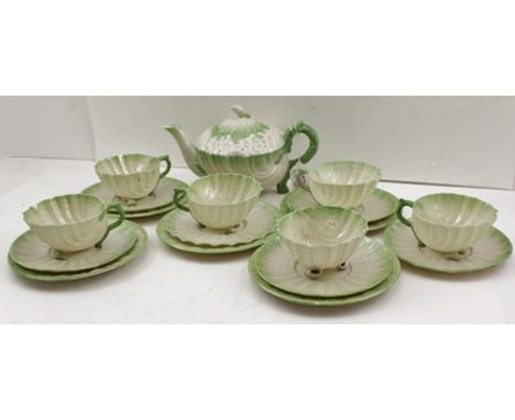 A BELLEEK PART TEA SERVICE, the Parian body moulded in shell designs, green tinted, includes teapot, five plates, six saucers