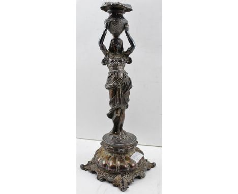 AN EARLY 20TH CENTURY SILVER PLATED CANDLE STICK, the stem in the form of a young woman in Egyptian costume, bearing the nozz