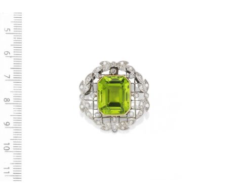 A Belle époque Peridot and diamond brooch, circa 1910The cut cornered step-cut peridot within a rose-cut diamond garland surr