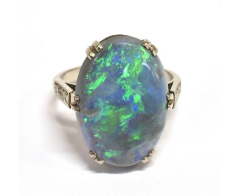 A STAMPED 18CT BLACK OPAL DOUBLET AND DIAMOND RING The large Oval Opal measuring approx. 1.9cm X 1.5cm, 'Potch' type backing 