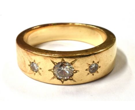 A GENTLEMAN'S DIAMOND THREE STONE GYPSY RING  the ring star set with three graduated round cut diamonds, the central diamond 