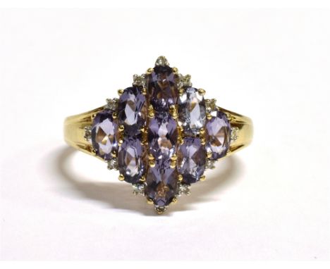 A 9CT GOLD AMETHYST CLUSTER RING The lozenge shaped cluster set with nine round cut light amethysts and diamond accents, meas