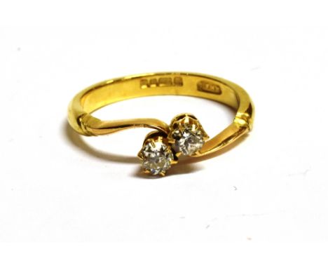 AN 18CT GOLD, DIAMOND TWO STONE CROSSOVER RING The two diamonds each measuring approx 2mm in diameter on a yellow gold band w