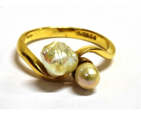 AN 18CT GOLD BLISTER PEARL AND SHELL CROSS OVER RING The ring set with one blister pearl and one shell pearl, the ring hallma