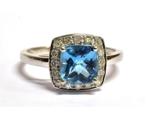 9CT WHITE GOLD DIAMOND CLUSTER RING The ring set with a cushion cut faceted sky blue gemstone measuring 7 x 7mm with a mount 