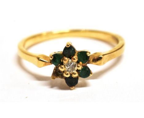 A DIAMOND AND GREEN STONE FLOWER HEAD RING The ring set with a small central diamond with green stone petals (one green stone