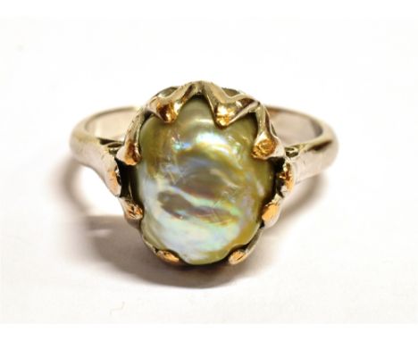 A WHITE METAL SHELL PEARL RING The ring set with an oval shell pearl measuring 1.2 x 1cm, ring size O, weight 5.4g