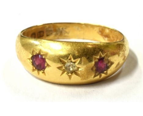 AN 18CT GOLD GEM SET GYPSY RING  the ring set with a central star set clear quartz stone and flanked each side with a red sto