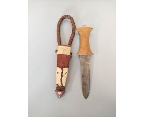 A Sudanese arm knife with tapering straight blade and carved wooden hilt. Contained in tooled leather scabbard with twisted l