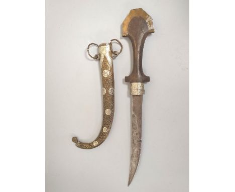 Arabic Jambiya dagger of elongated form with white metal and brass mounts and wooden handle.&nbsp; 