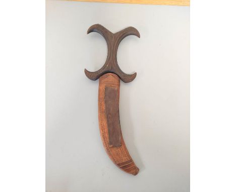 A Sudanese Beja dagger with&nbsp;sharply curving blade and characteristic X-form carved wooden handle of large size decorated