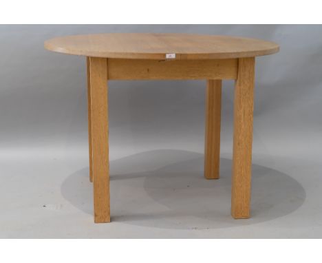 A modern circular golden oak dining table , having integral leaf extension on square chunky legs, closed diameter approx. 110