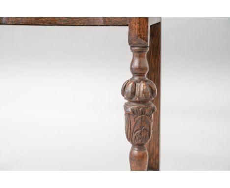 An early 20th Century oak side table having ledge back, shaped front and single frieze drawer, on bulbous column and turned l