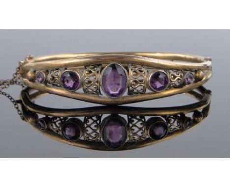 A Victorian amethyst set gilt metal hinged bangle.