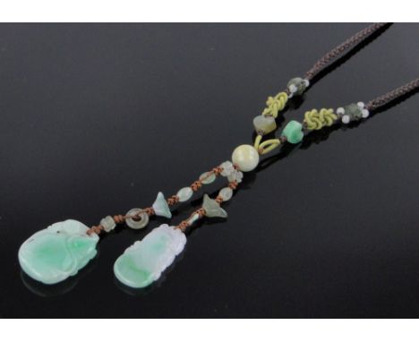 A Chinese carved and pierced jade double pendant necklace,with jade bead mounts on silk cord.