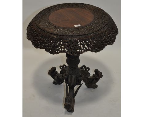 A Burmese carved rosewood centre table,with a carved pierced and shaped frieze, turned centre column and dragon tripod legs, 