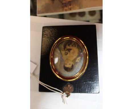 An oval miniature portrait depicting John Edward Scott, son of Robert Falcon Scott of the Antarctic seated and holding a pupp