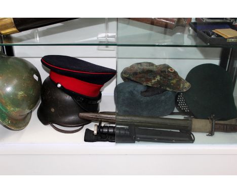 A German military steel helmet, a gas mask, two caps and a Russian military hat together with various bayonets and knives, et