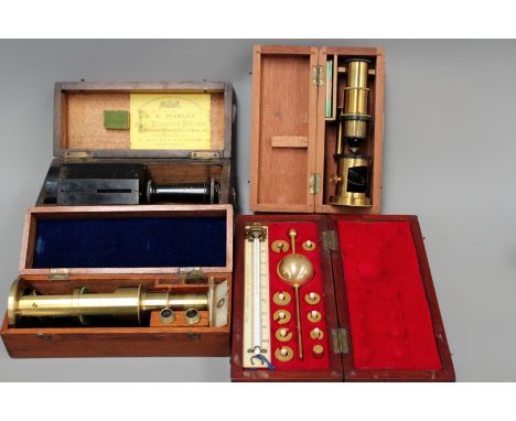 An early 20th Century brass small field microscope in mahogany case, a similar later example, a Sike’s hydrometer in fitted c