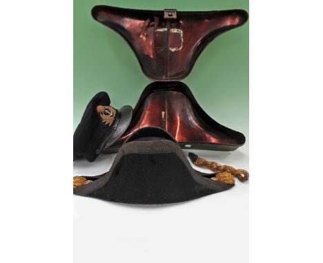 A 19th Century naval bicorn hat contained in original tin case labelled “W C Adams R N”. Together with a later naval peak cap