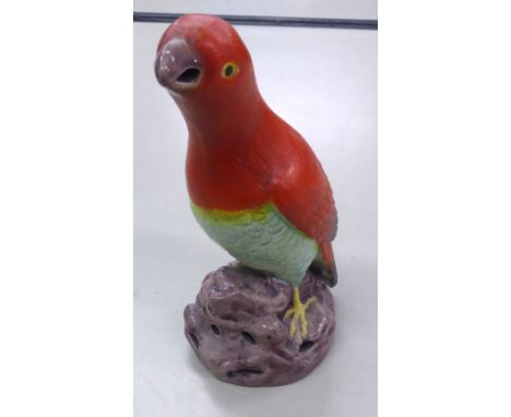 A POTTERY MODEL OF A PARROT STANDING ON A ROCK, 7" HIGH 
