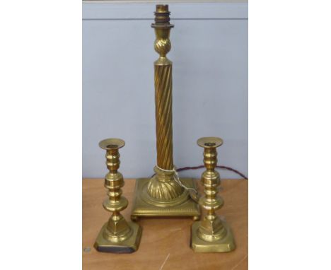 A BRASS SPIRALLY FLUTED TABLE LAMP, A PAIR OF BRASS TABLE CANDLESTICKS, ON SQUARE BASES 