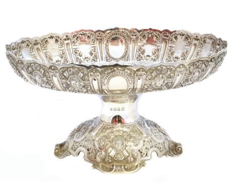 An early 20th Century silver tazza, the oval bowl with scalloped rim and repous sé figural decoration with a tapered stem and