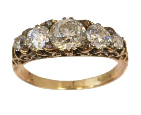 A diamond five stone ring, the graduated old cut diamond line with rose cut diamond spacers and scrolling shoulders, stamped 