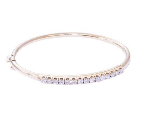 A diamond hinged bangle, designed as a raised brilliant cut diamond line with plain polished reverse, stamped 18K, estimated 