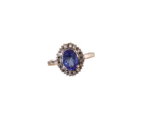 An 18ct gold tanzanite and diamond cluster ring, the oval shape tanzanite within an undulating tapered baguette cut diamond s