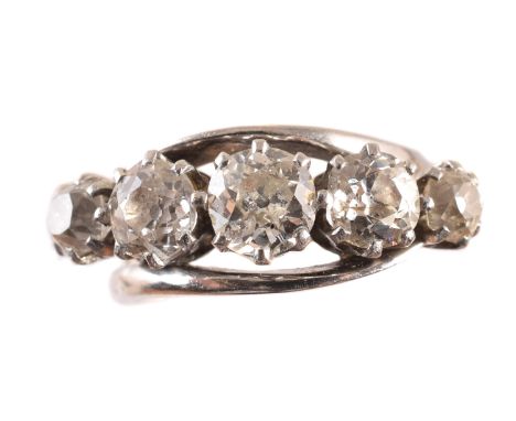 An 18ct gold diamond five stone ring, designed as an old cut diamond line with crossover shoulders, hallmarks for Birmingham,