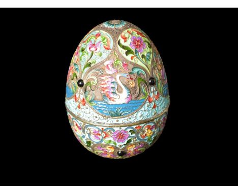 A RUSSIAN SILVER GILT AND CLOISONNE ENAMEL JEWELLED EGG THE TWO HALVES DECORATED WITH SWANS AND FLORAL MOTIFS WITHIN RESERVES