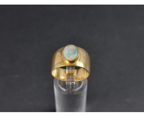 A yellow metal opal ring, having bezel set stone, size T. 